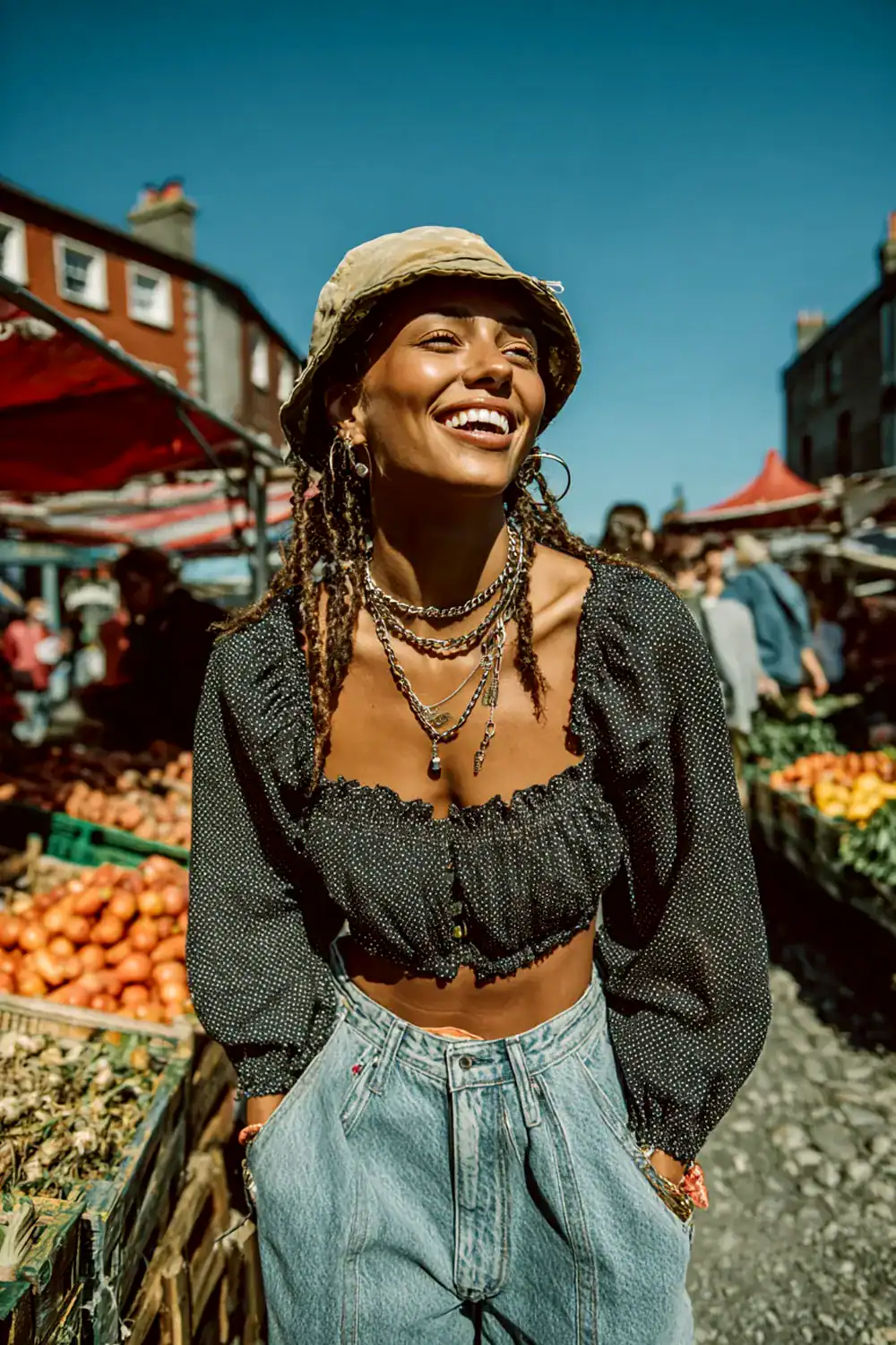 Lachende Frau im 90er Street Style mit Mom Jeans, schwarzem Crop Top, Bucket Hut und Ketten auf einem Markt