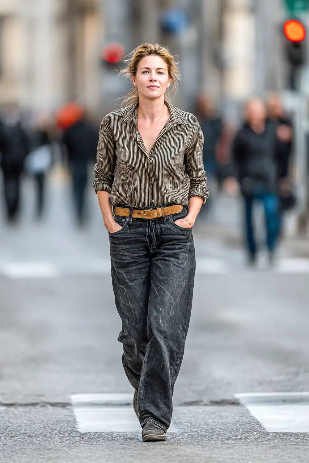 Frau über 40 in entspanntem Herbst Outfit mit dunklen Jeans und gestreifter Bluse beim Stadtspaziergang – lässiger Casual Look